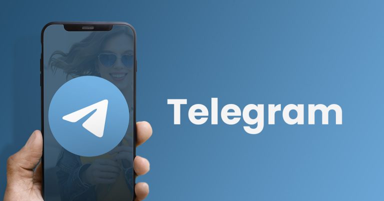 mão a segurar telemóvel com o cone de telegram
